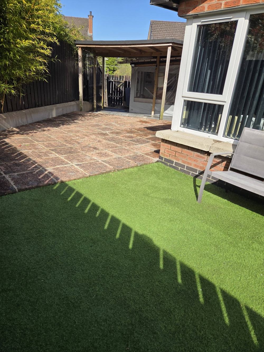 The same garden cleared and swept, patio and lawn clear and usable again.